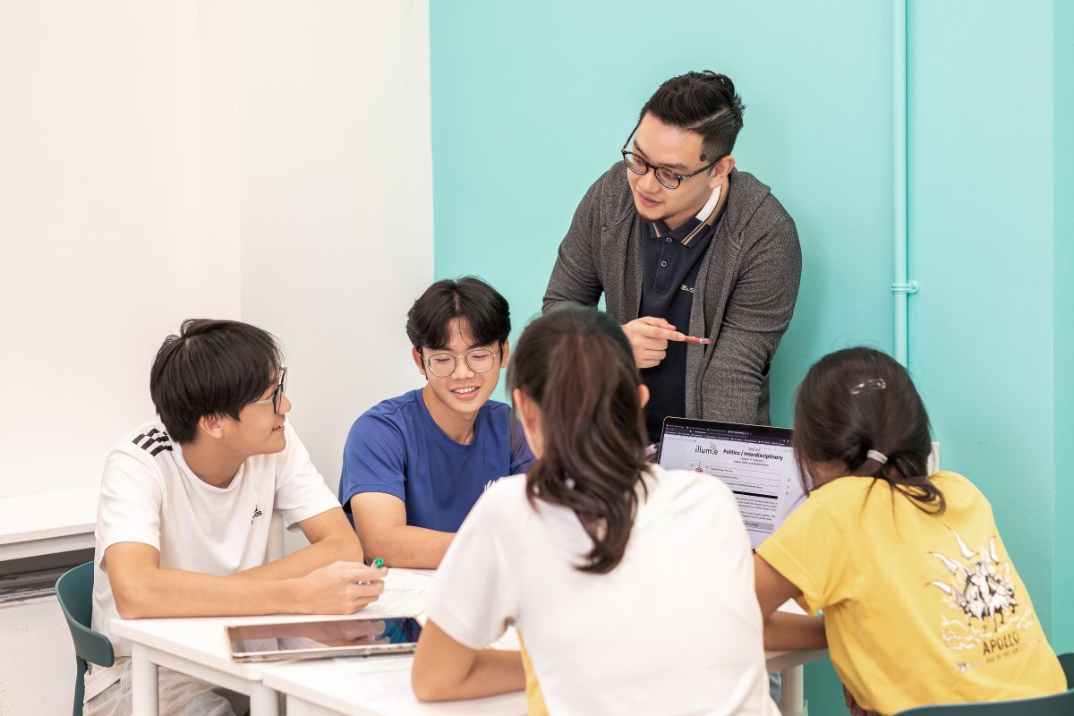Teacher discussing with students in small group tuition class for GP and English