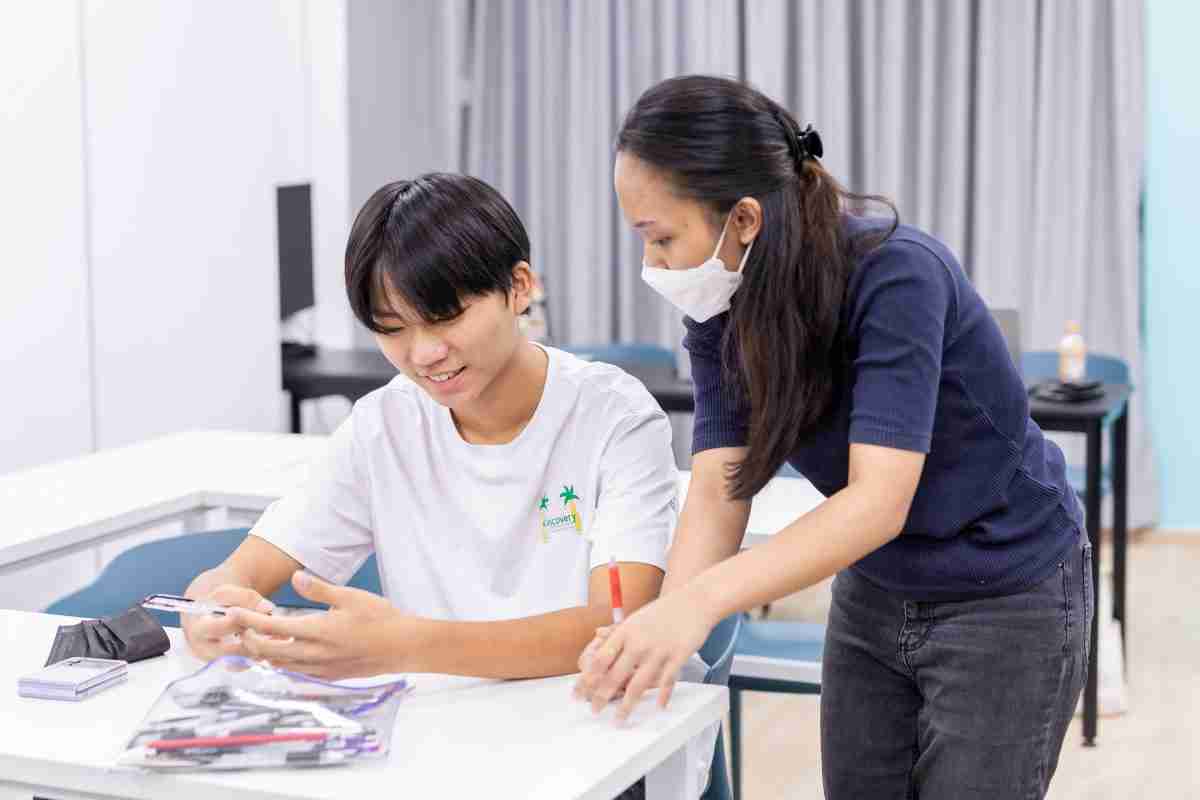 Teaching assistant gives close feedback during English Class