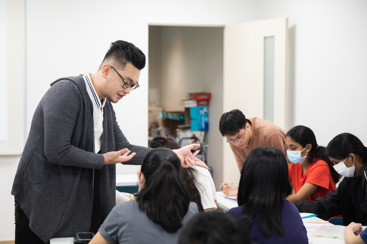 Students receiving close feedback from different teachers during GP class from Mr Chia and Mr Liew