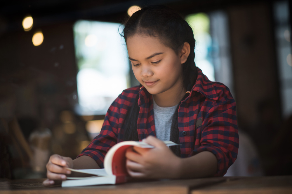 student reading a book and studying for PSLE