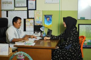 A parent sits down with their child’s teacher for a parent-teacher meeting.