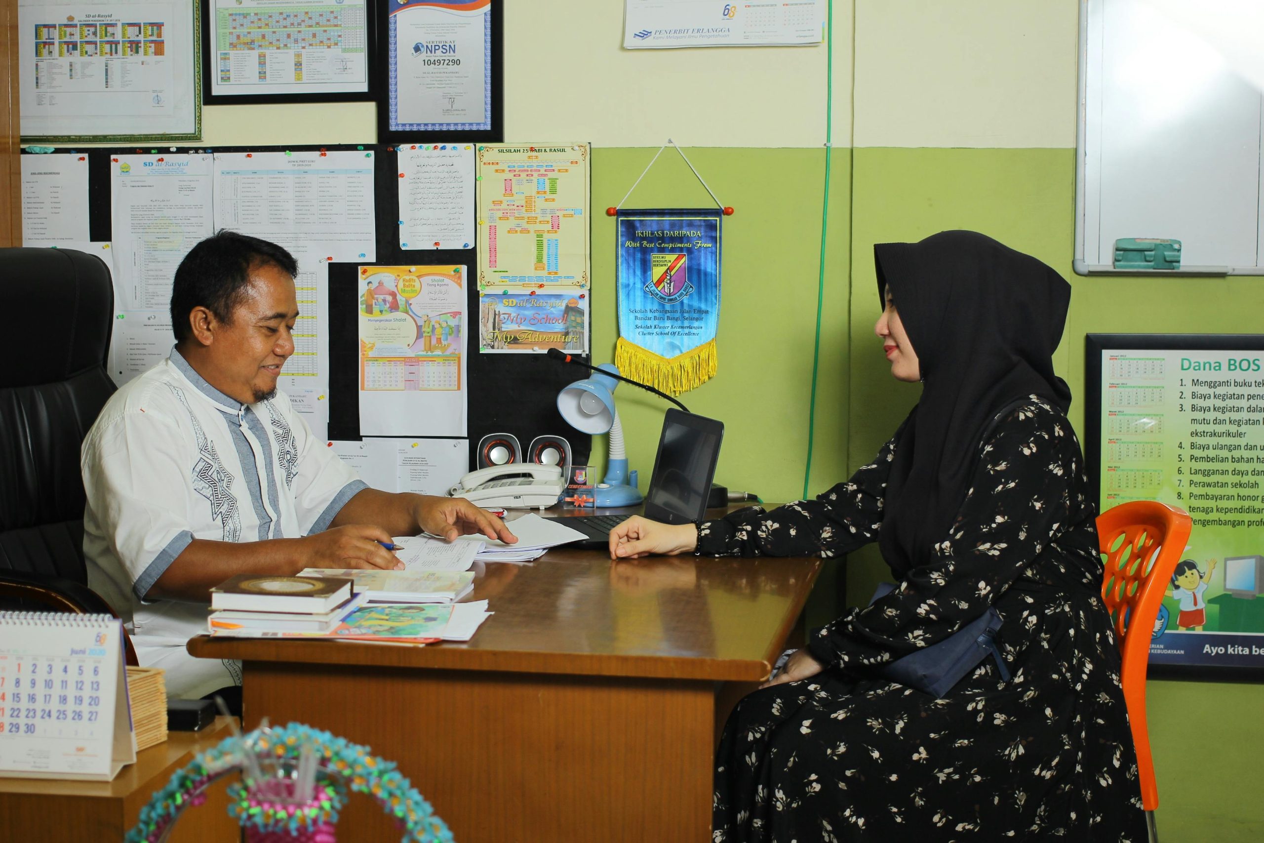A parent sits down with their child’s teacher for a parent-teacher meeting.